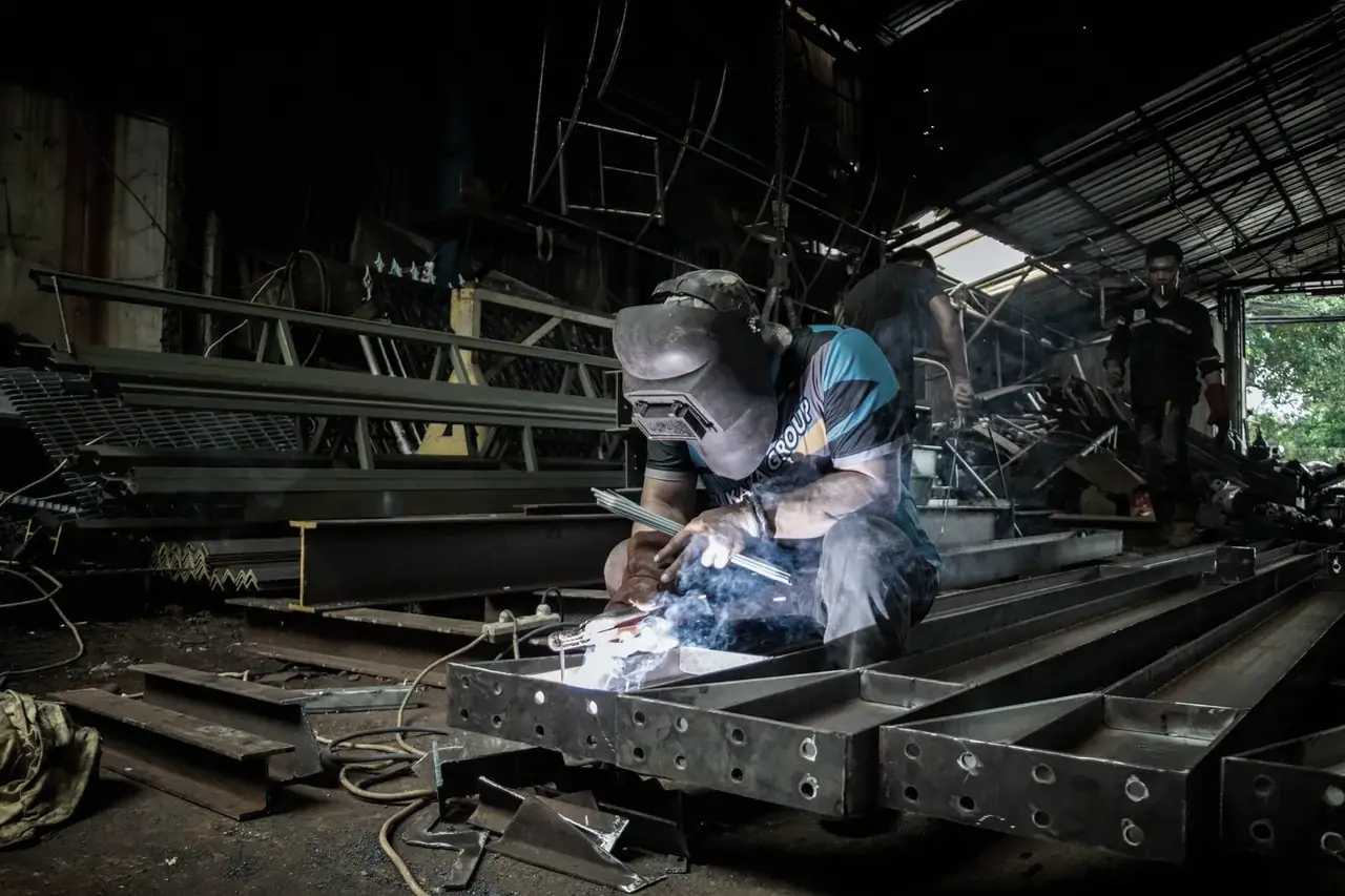 Fabricator welding stainless steel in a workshop