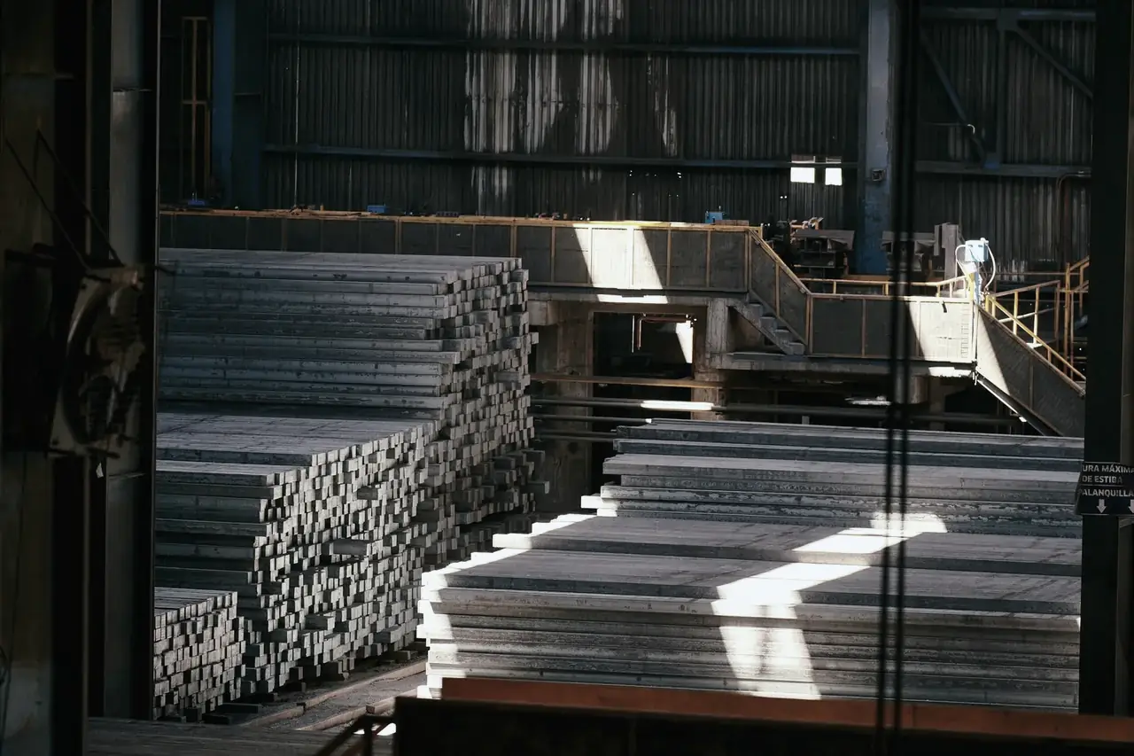 Stacked steel plates and sections inside an industrial warehouse